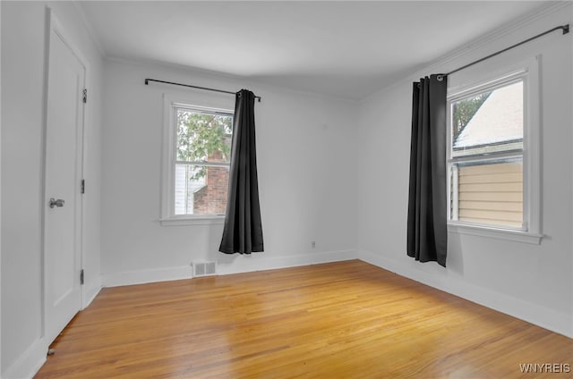 unfurnished room with wood-type flooring, plenty of natural light, and crown molding