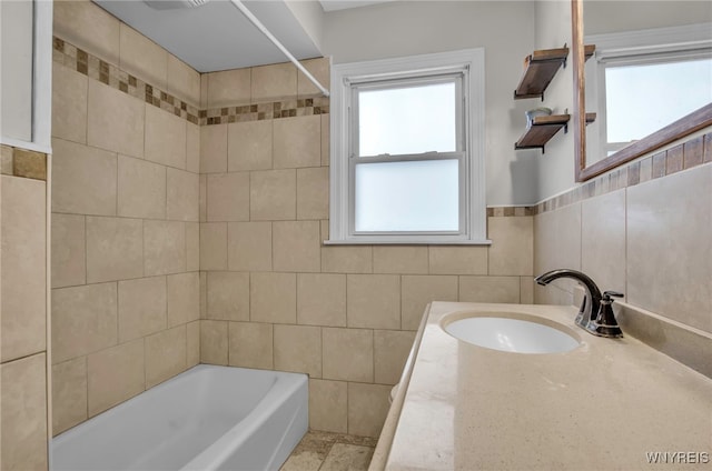 bathroom with tub / shower combination, vanity, tile walls, and decorative backsplash