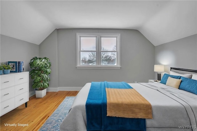 bedroom with light hardwood / wood-style flooring and lofted ceiling