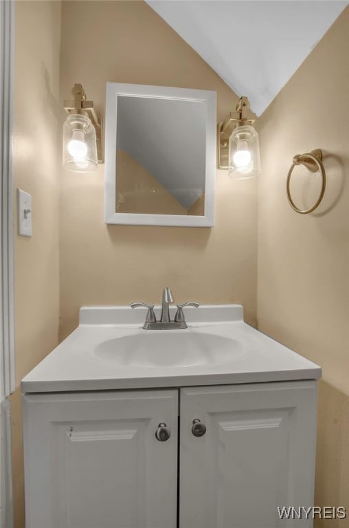 bathroom with lofted ceiling and vanity