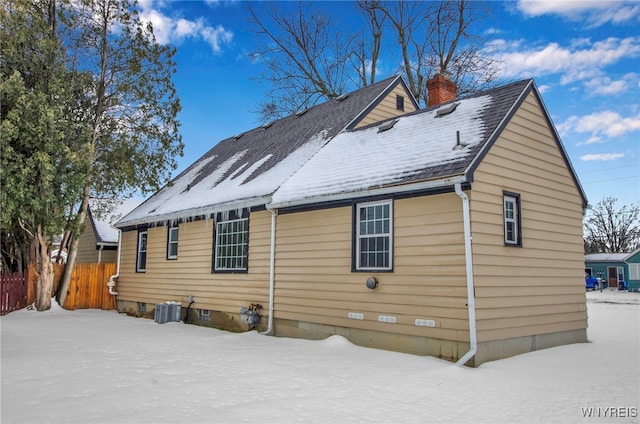 snow covered back of property with central AC unit