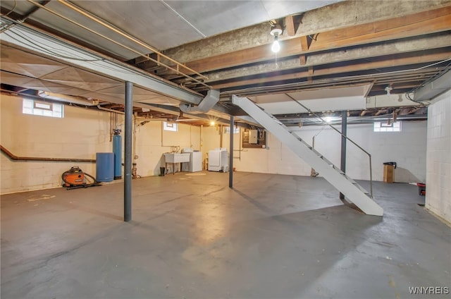 basement with sink, washer and clothes dryer, and electric panel