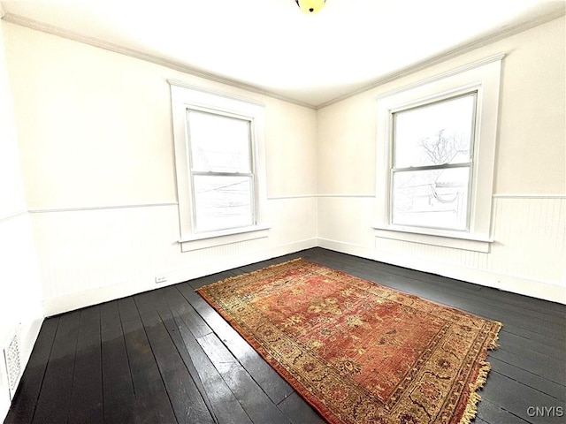 spare room with wood-type flooring and ornamental molding