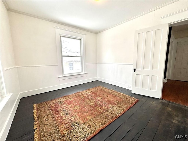 spare room featuring dark hardwood / wood-style flooring and ornamental molding