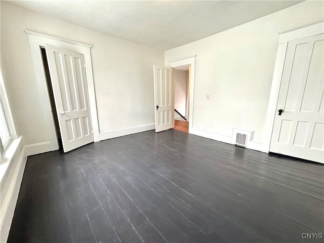 unfurnished bedroom featuring dark wood-type flooring