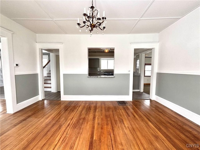 unfurnished living room featuring a chandelier and wood-type flooring