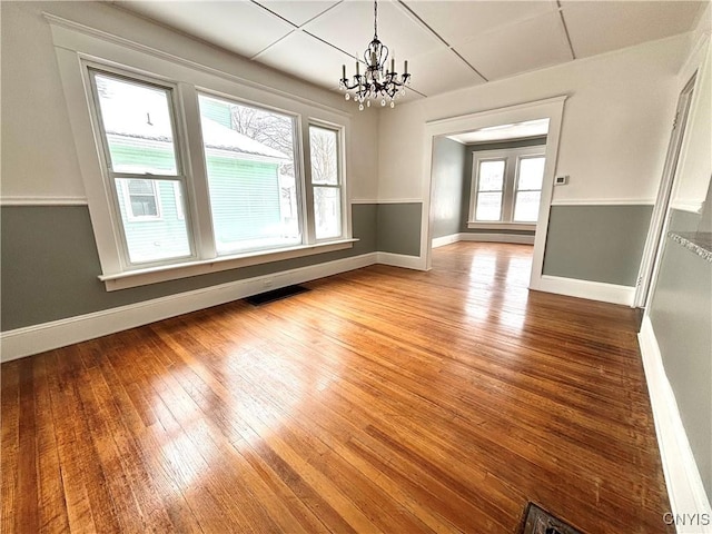 unfurnished dining area with hardwood / wood-style flooring and an inviting chandelier