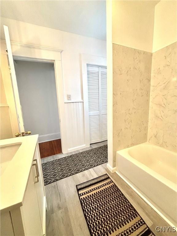 bathroom with a bath, wood-type flooring, and vanity