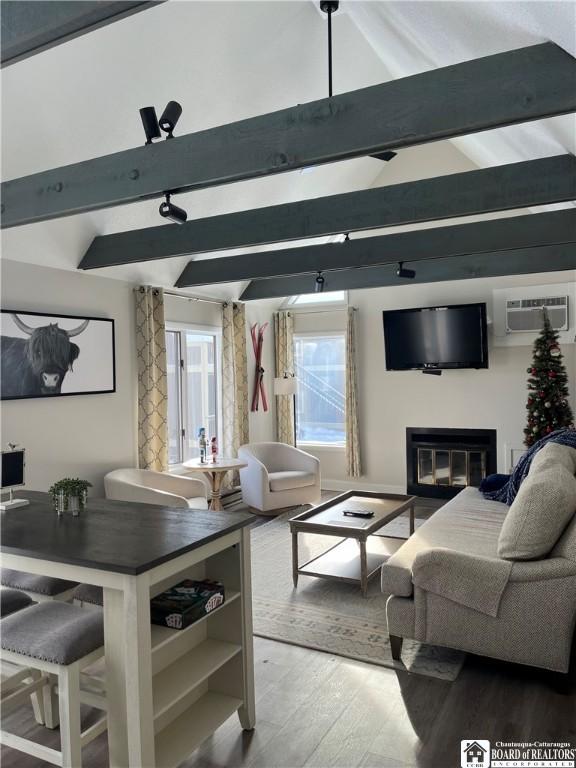 living room featuring vaulted ceiling with beams, a wall mounted AC, and hardwood / wood-style flooring