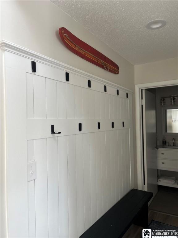 mudroom with a textured ceiling and sink