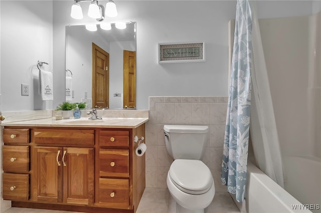 full bathroom featuring toilet, vanity, tile walls, tile patterned floors, and shower / bath combo