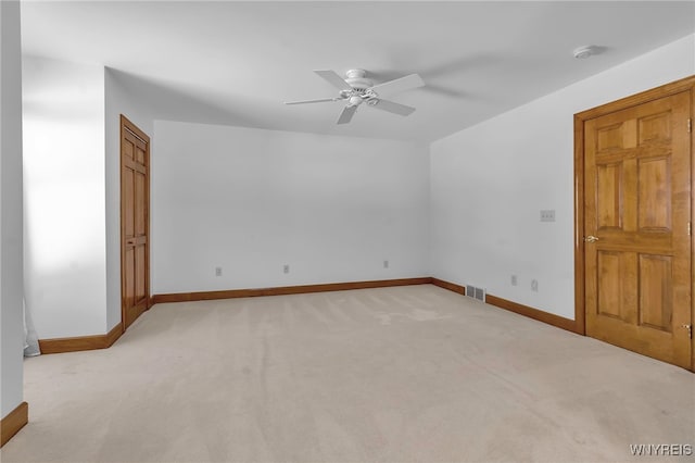 empty room with ceiling fan and light colored carpet