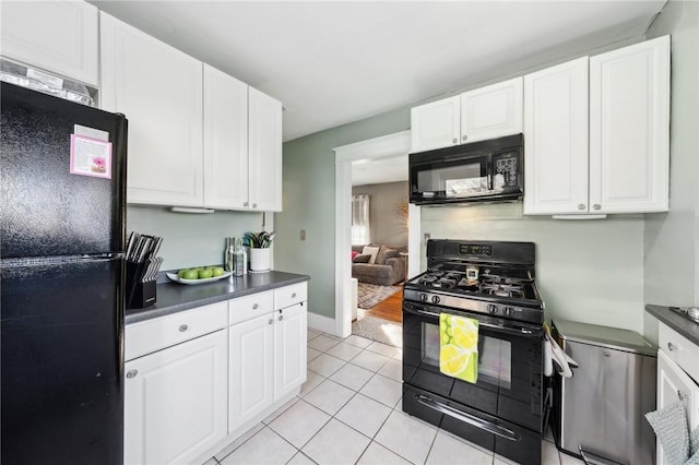 kitchen featuring black appliances, light tile patterned floors, and white cabinetry