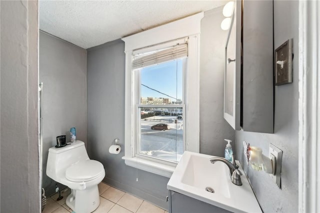 bathroom with toilet, vanity, tile patterned flooring, and a textured ceiling