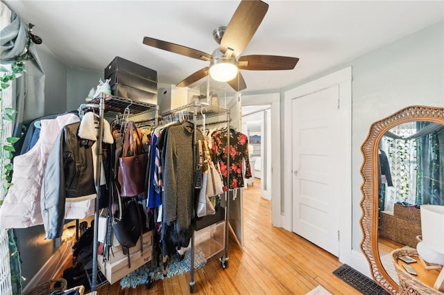 walk in closet with ceiling fan and light hardwood / wood-style flooring