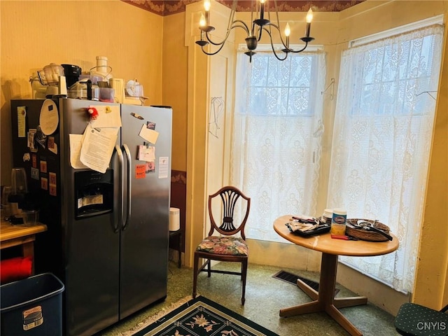 kitchen featuring stainless steel fridge and a notable chandelier