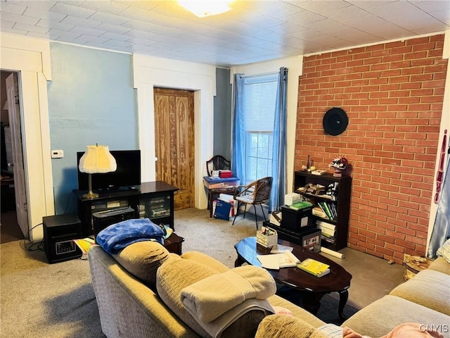 carpeted living room with brick wall