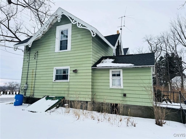 view of snow covered rear of property