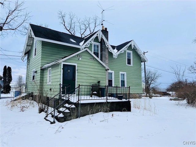 view of snow covered back of property