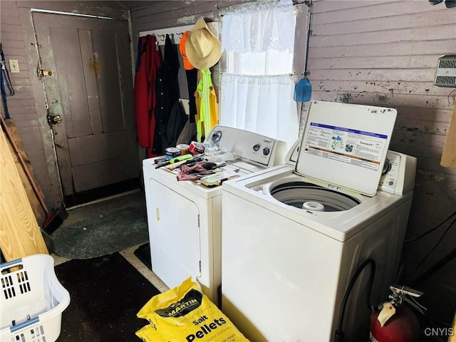 laundry room featuring washer and dryer and wood walls