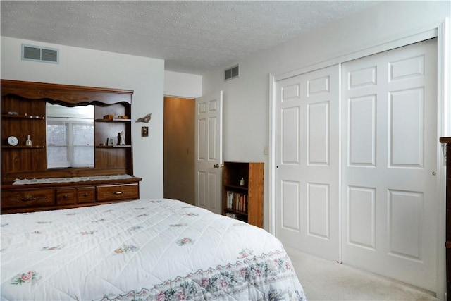 carpeted bedroom featuring a textured ceiling and a closet