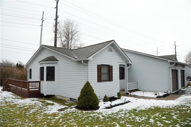 snow covered rear of property with a garage