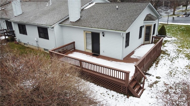 snow covered rear of property with a wooden deck