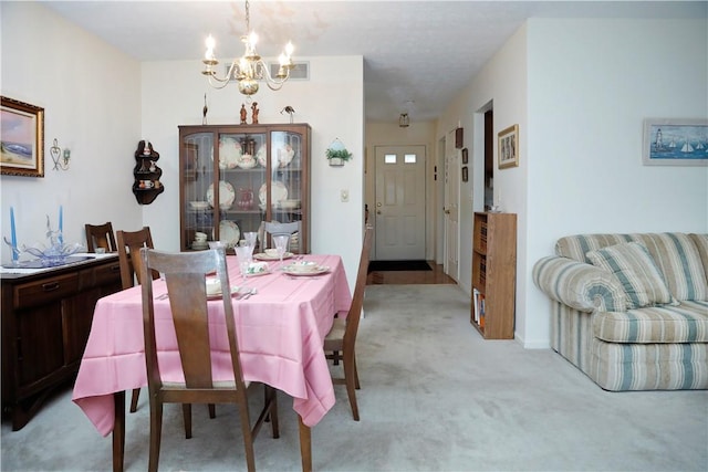 carpeted dining room with a chandelier