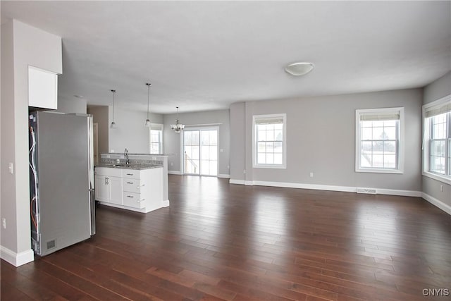 unfurnished living room featuring a wealth of natural light, dark hardwood / wood-style floors, and sink