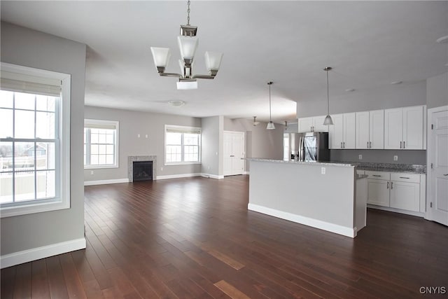 kitchen featuring white cabinets, a center island, stainless steel refrigerator with ice dispenser, dark hardwood / wood-style flooring, and hanging light fixtures