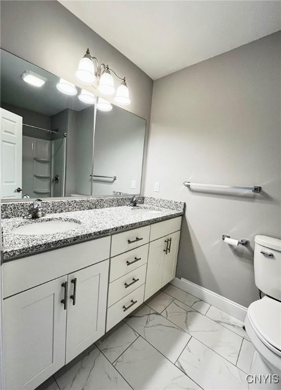 bathroom with walk in shower, vanity, and toilet