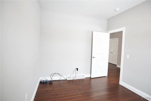 empty room with dark hardwood / wood-style flooring