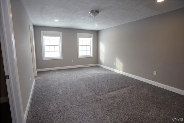 spare room with a textured ceiling and carpet flooring