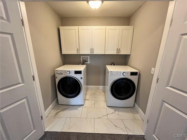 clothes washing area featuring cabinets and washing machine and clothes dryer