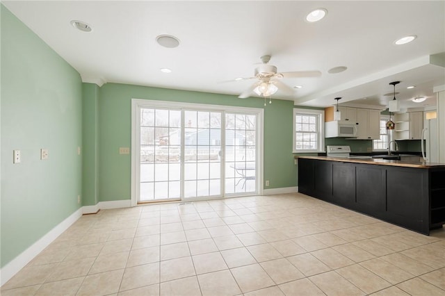 kitchen with stove, light tile patterned floors, kitchen peninsula, and hanging light fixtures