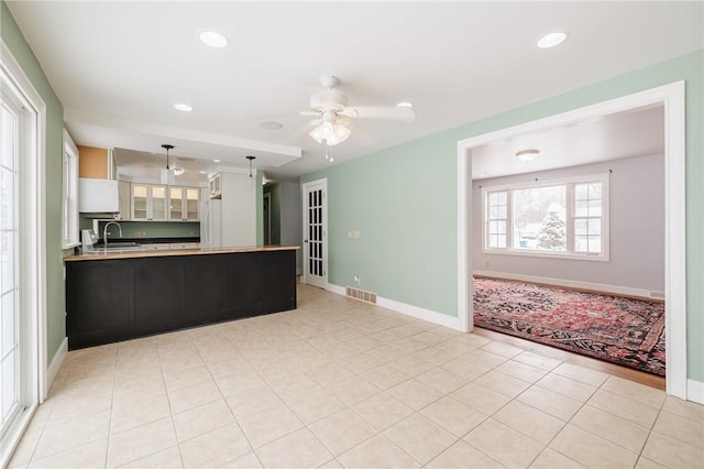 kitchen with decorative light fixtures, white cabinetry, sink, kitchen peninsula, and ceiling fan