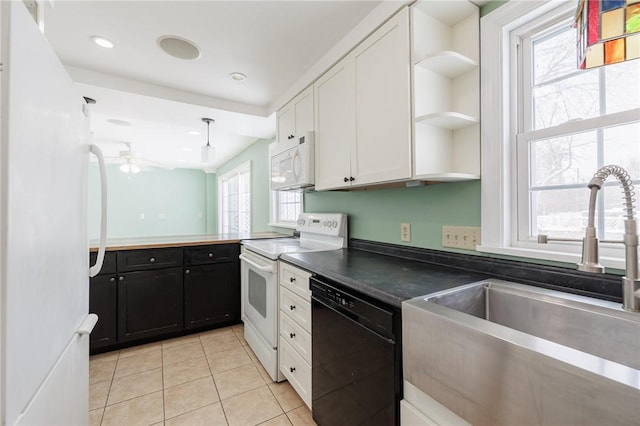 kitchen with light tile patterned floors, sink, white appliances, and white cabinetry