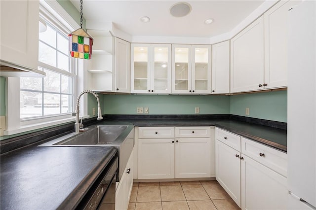 kitchen featuring light tile patterned floors, a wealth of natural light, white cabinets, and black dishwasher