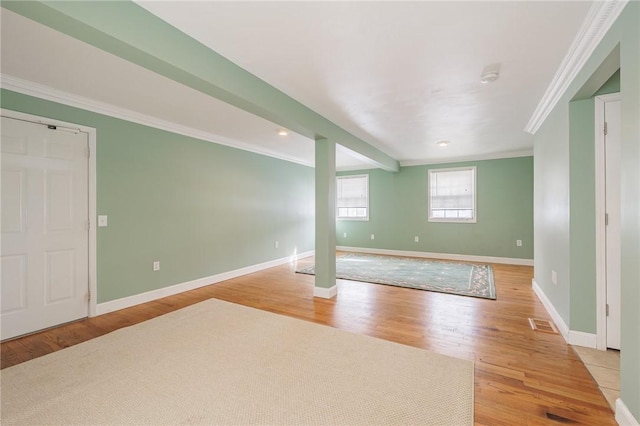 spare room with light wood-type flooring and ornamental molding