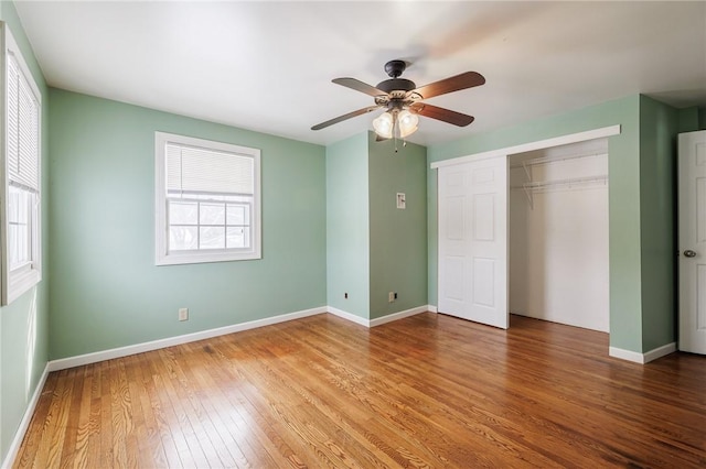 unfurnished bedroom with ceiling fan, a closet, and wood-type flooring