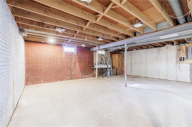 basement with brick wall and electric panel