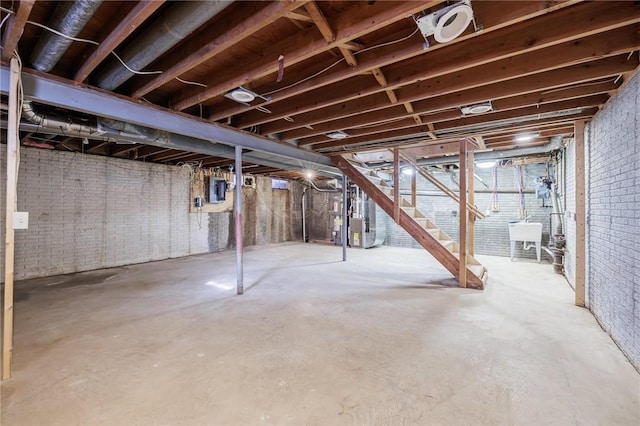 basement with sink, electric panel, and heating unit