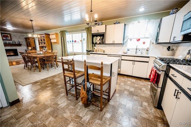 kitchen with wooden ceiling, an inviting chandelier, a sink, and stainless steel appliances