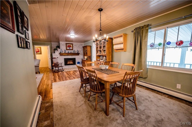 dining room featuring a fireplace, wooden ceiling, a baseboard heating unit, wood finished floors, and a notable chandelier