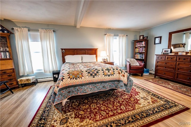 bedroom with beam ceiling, a baseboard heating unit, and light wood-type flooring