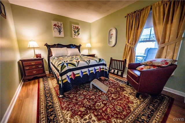 bedroom featuring baseboards and wood finished floors
