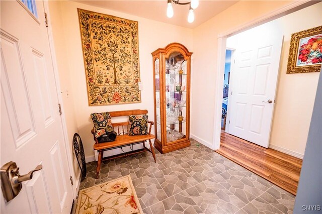 foyer featuring stone finish floor and baseboards