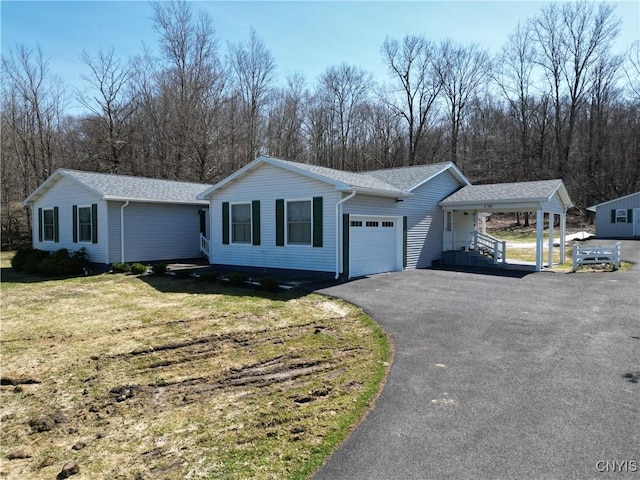 ranch-style home featuring roof with shingles, driveway, an attached garage, and a front lawn