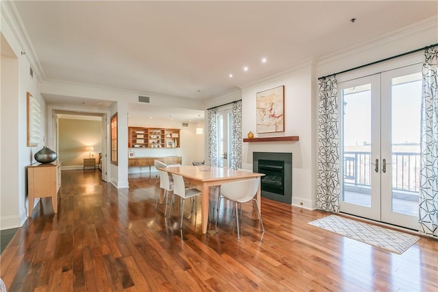 dining area featuring french doors, ornamental molding, and hardwood / wood-style flooring