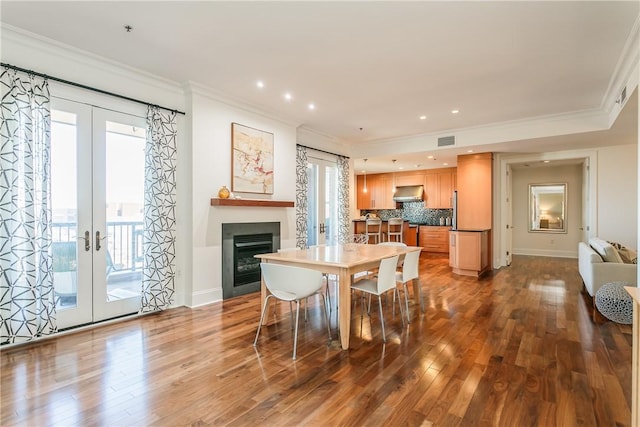 dining room with french doors, ornamental molding, and wood-type flooring